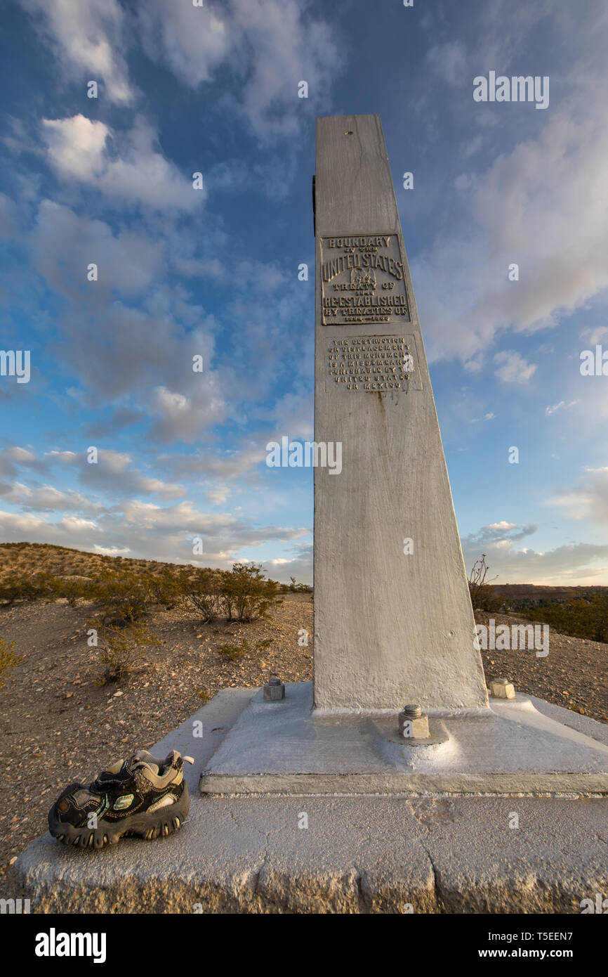 Un bimbo a scarpa si appoggia alla base di un US-Messico monumento di confine vicino al Anapra Gap, un popolare punto di incrocio per i migranti nei pressi di El Paso, Texas Foto Stock