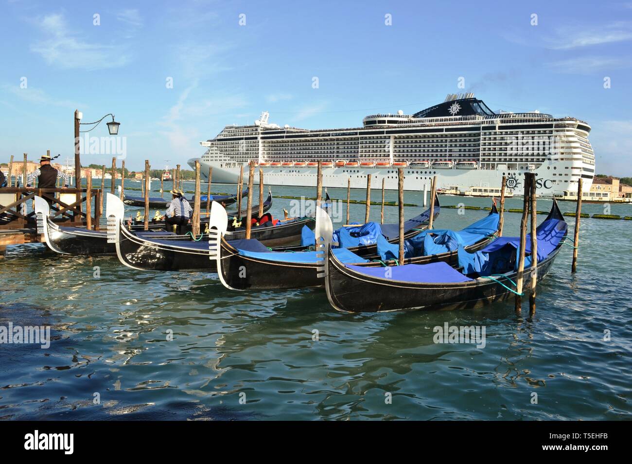 Venezia/Italia - 20 Aprile 2014: una vista panoramica di una nave da crociera MSC lasciando la laguna di Venezia nella soleggiata il giorno di Pasqua, gondoliere e gondole ancorate. Foto Stock