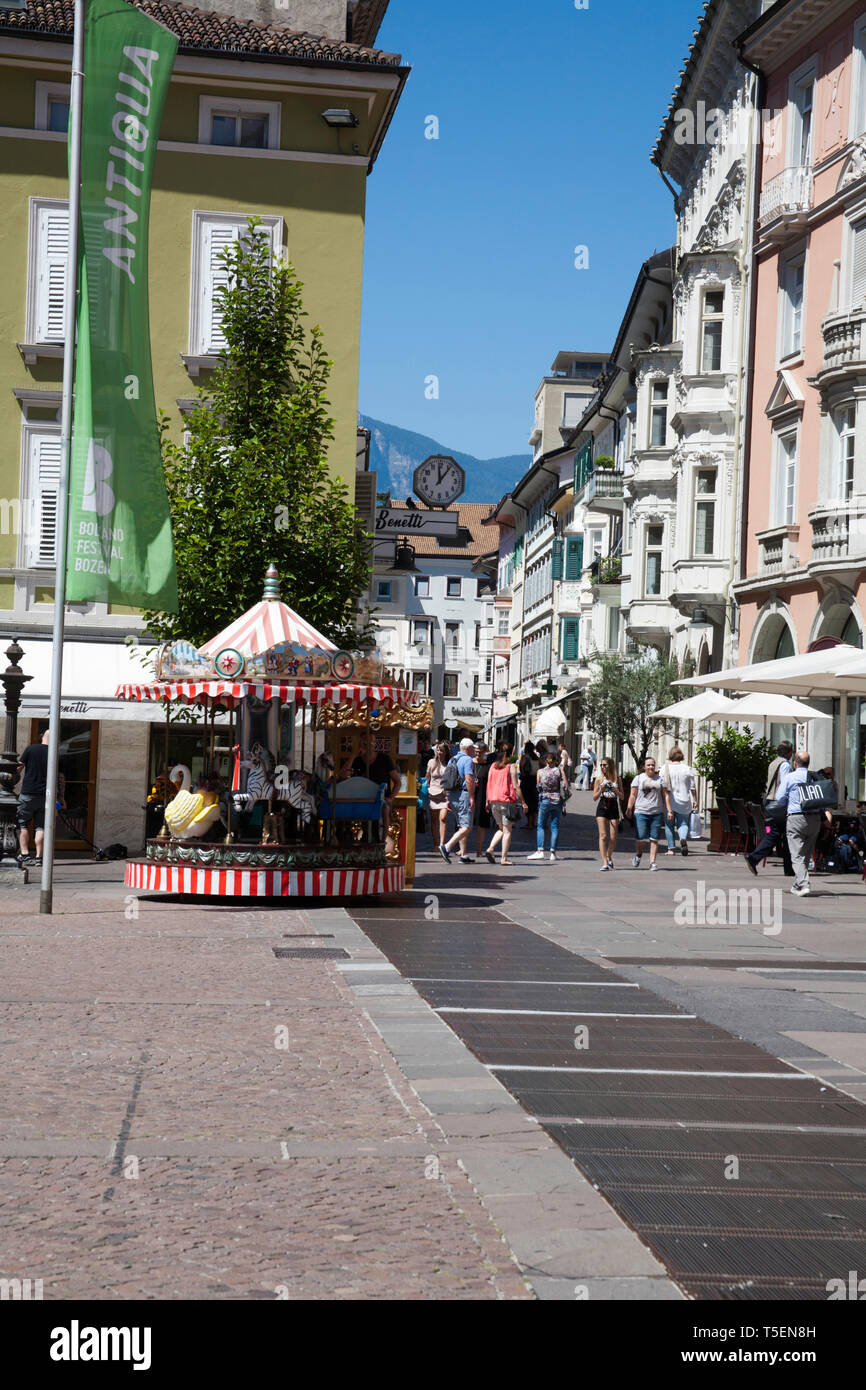 Negozi ristoranti e i bambini della fiera rotonda o giostra Via della Mostra Da Piazza Walther von De Vogelweide Bolzano Alto Adige Italia Foto Stock