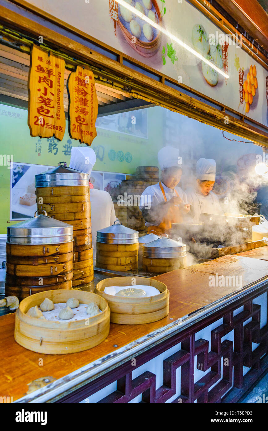 SHANGHAI, Cina, dicembre - 2018 - Donne cuochi preparare famoso damplings a cibo di strada stand nella città di Shanghai, Cina Foto Stock