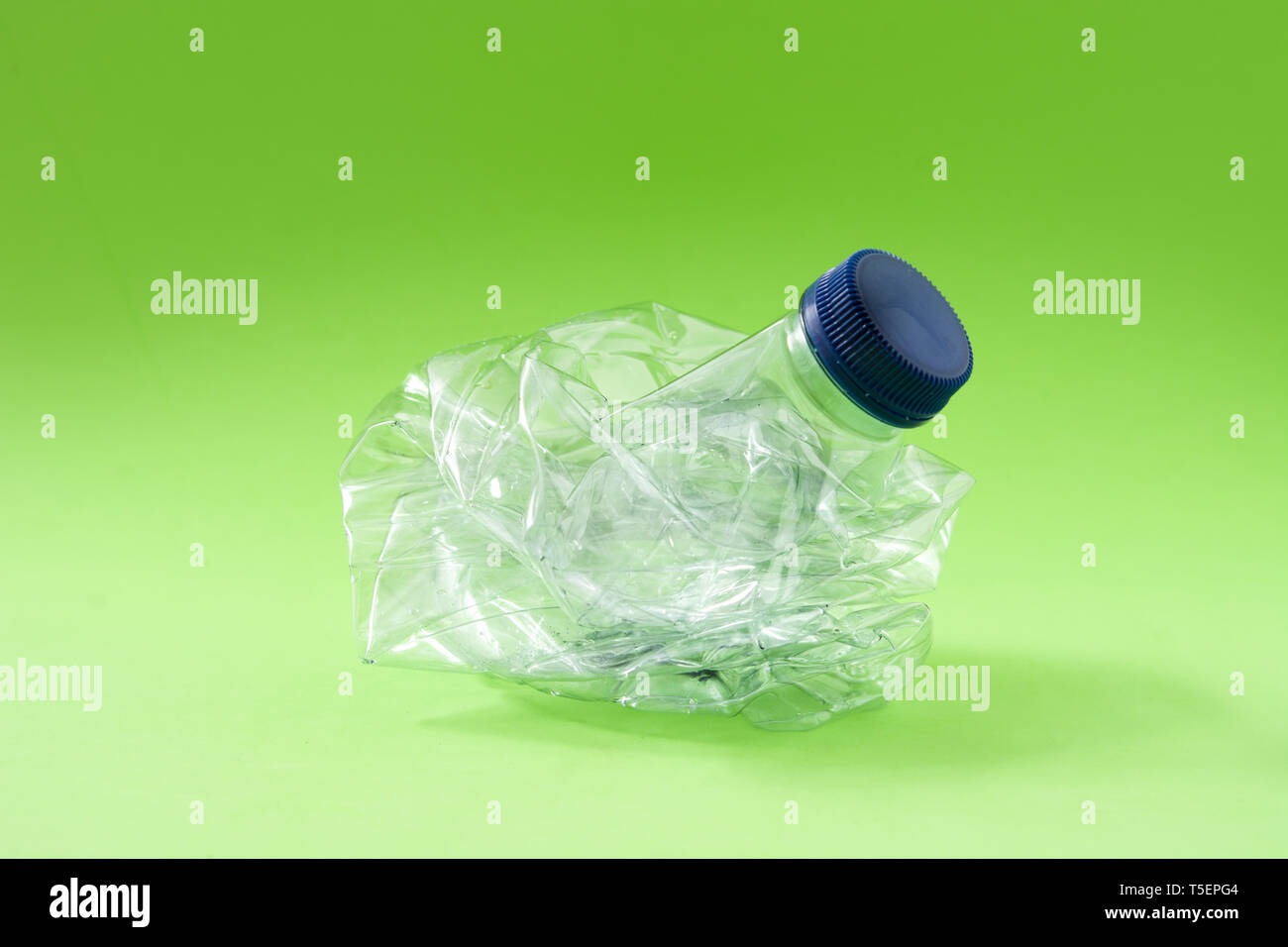 Rifiuti monouso bottiglia di plastica su sfondo verde Foto Stock