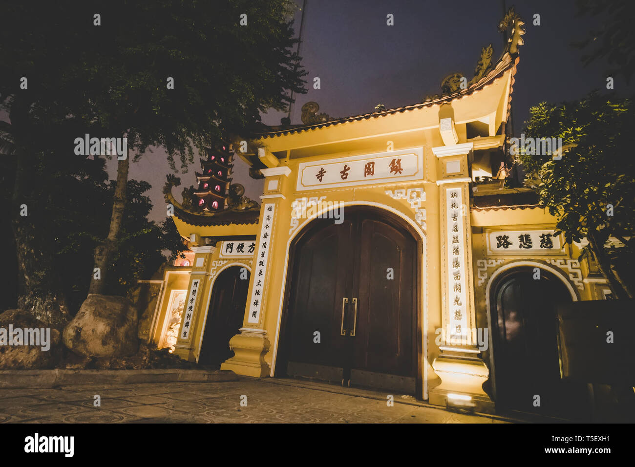 Ingresso al tempio buddista decorato con i caratteri cinesi, di notte Foto Stock