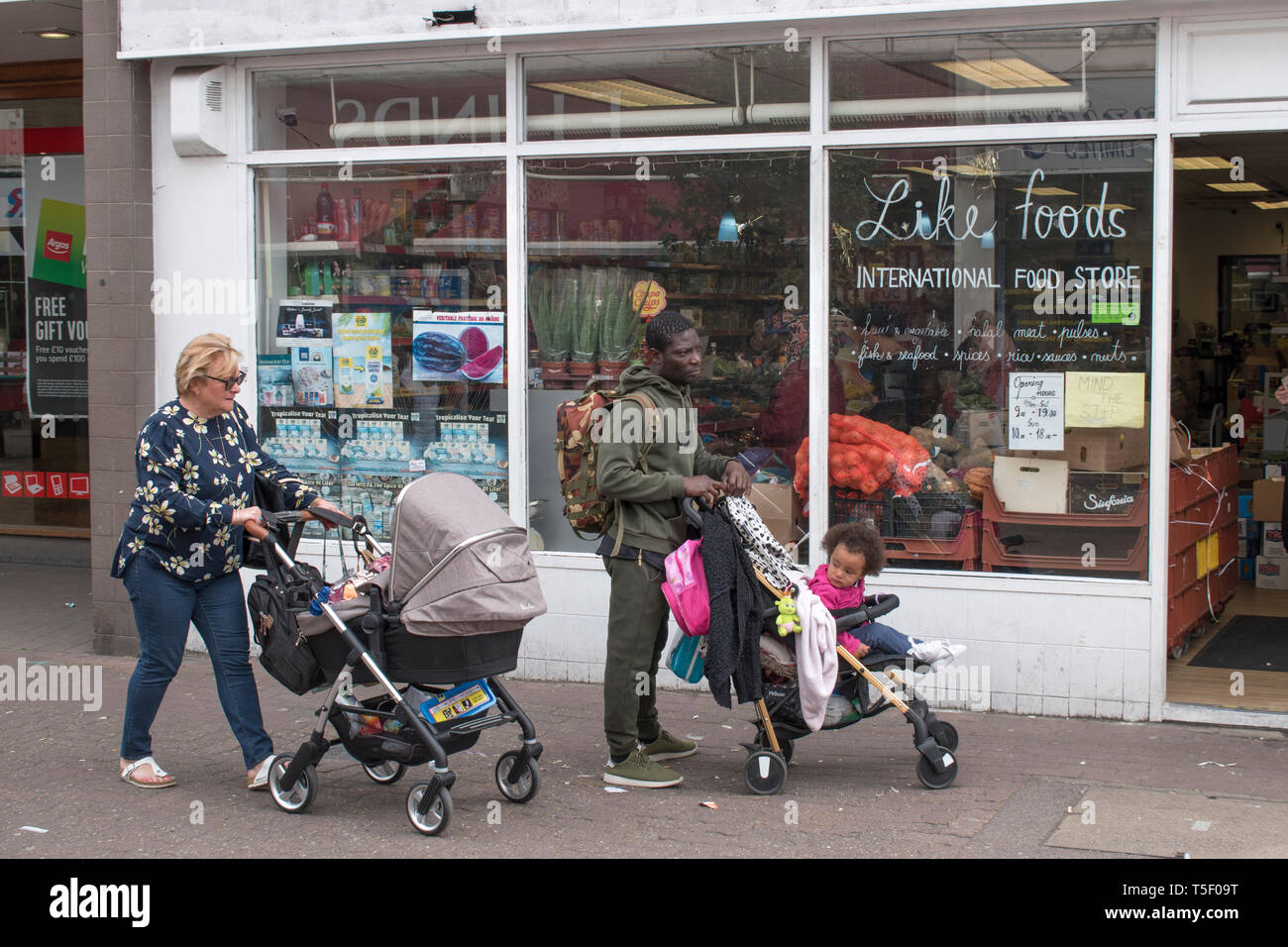 Gente della classe operaia multietnica, donna bianca, uomo britannico di colore con bambini in carrozzina che va a fare shopping a Dartford Kent anni '2019 2010 UK HOMER SYKES Foto Stock