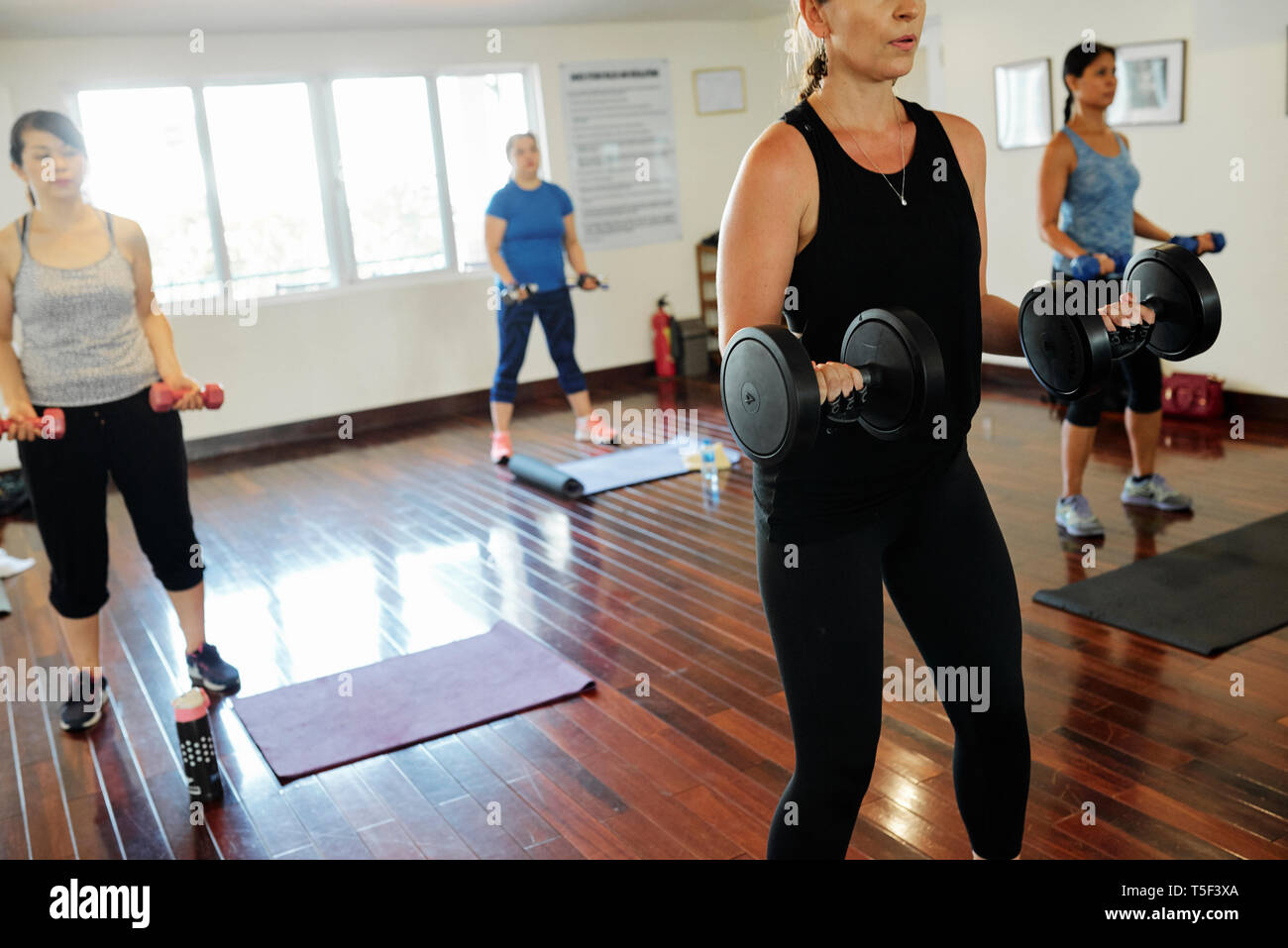 Le donne di peso di sollevamento in palestra Foto Stock