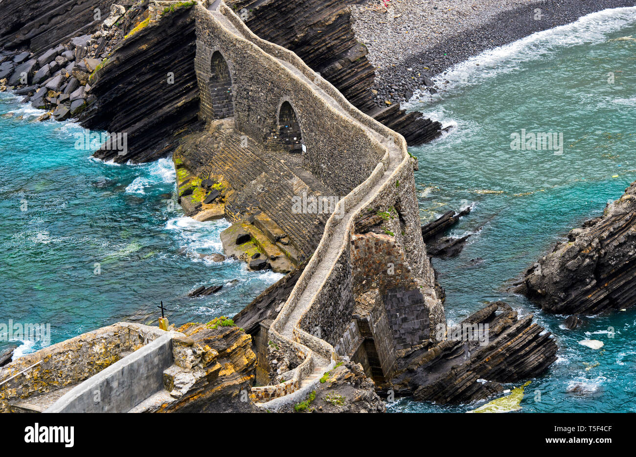 Ponte di pietra per l'isolotto Gaztelugatxe vicino a Bakio, Costa Vasca, nel golfo di Biscaglia, Paesi Baschi, Spanien Foto Stock