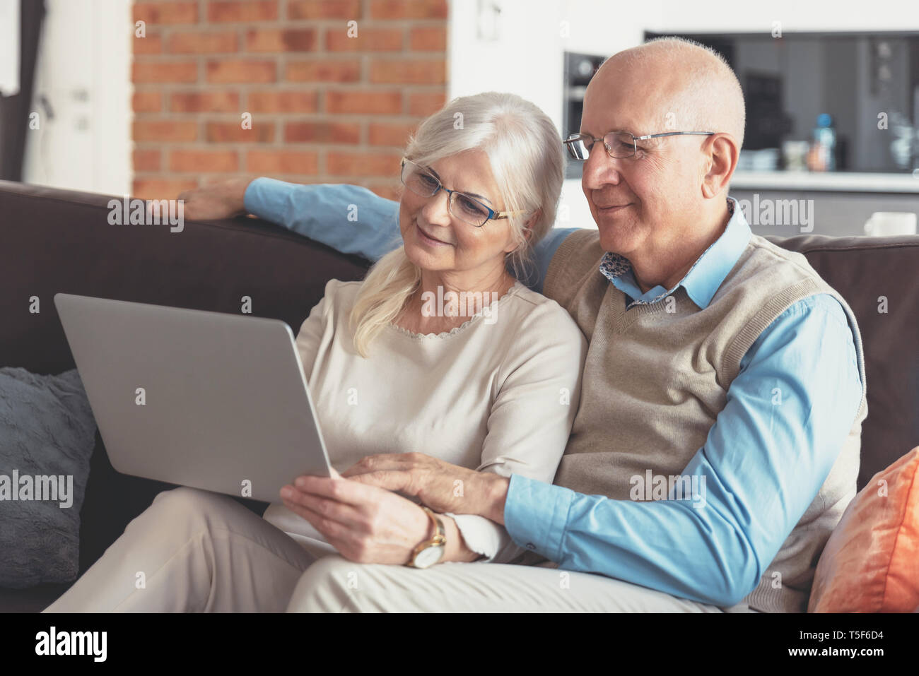 Coppia senior navigando in internet insieme. I pensionati utilizzando un computer portatile a casa Foto Stock