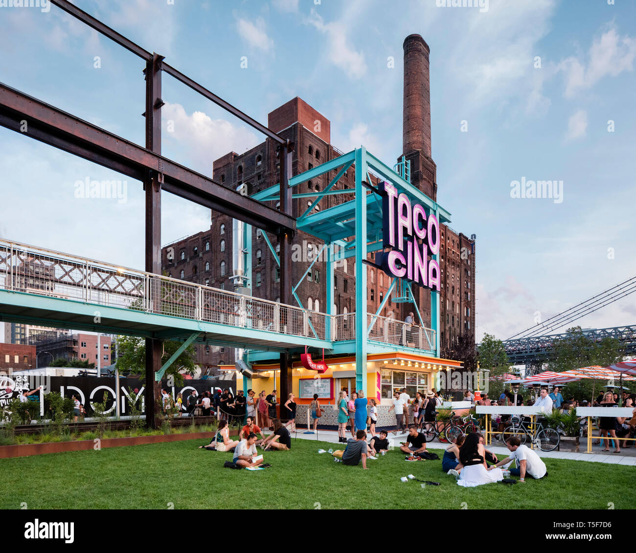 Ristorante Tacocina contro lo sfondo del Domino ex fabbrica di zucchero. Domino Park, Brooklyn, Stati Uniti. Architetto: James angolo opera sul campo Foto Stock