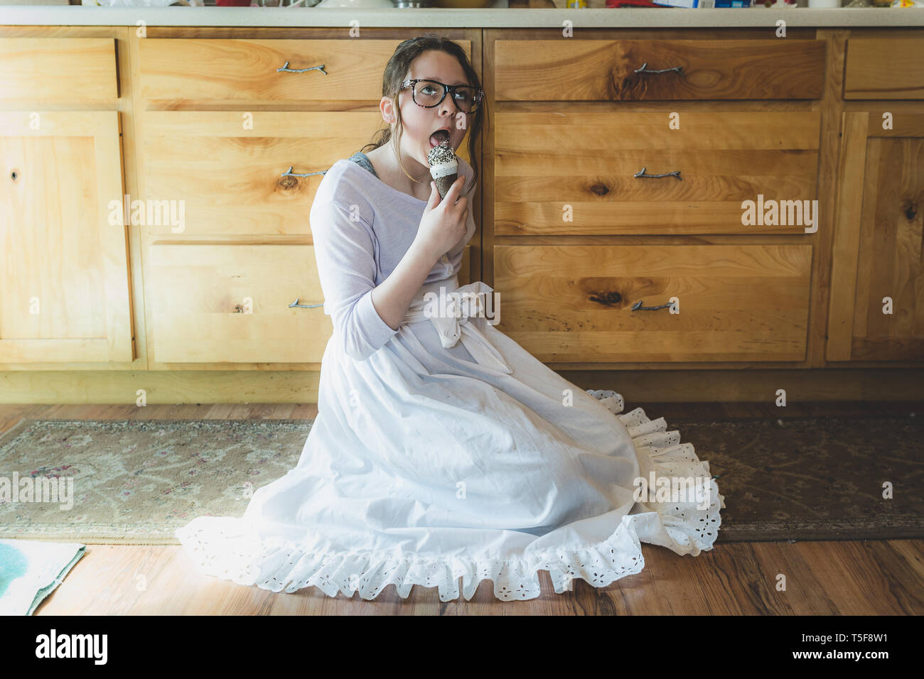 Teen girl eating cono gelato con gli occhiali Foto Stock