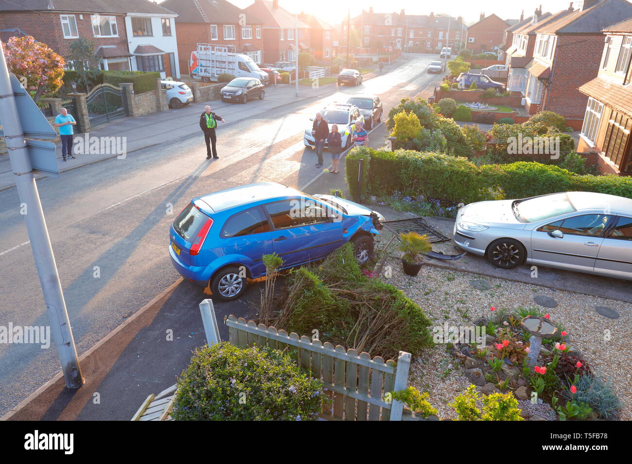 Scena di un traffico stradale collisione, dove un auto ha perso il controllo ed è venuto a riposo in un giardino. 2 occupanti sono stati visto correre lontano dalla scena. Foto Stock