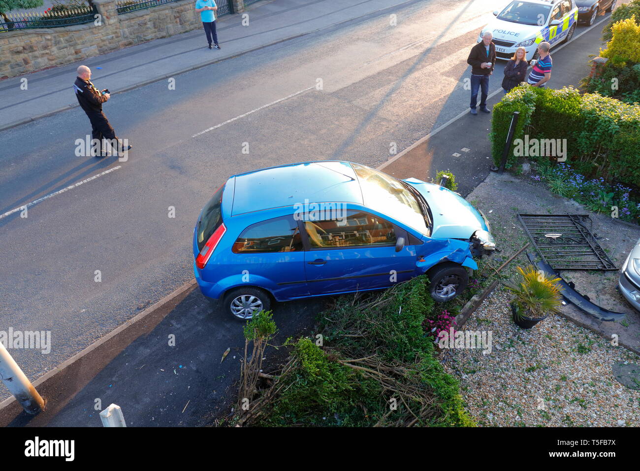 Scena di un traffico stradale collisione, dove un auto ha perso il controllo ed è venuto a riposo in un giardino. 2 occupanti sono stati visto correre lontano dalla scena. Foto Stock