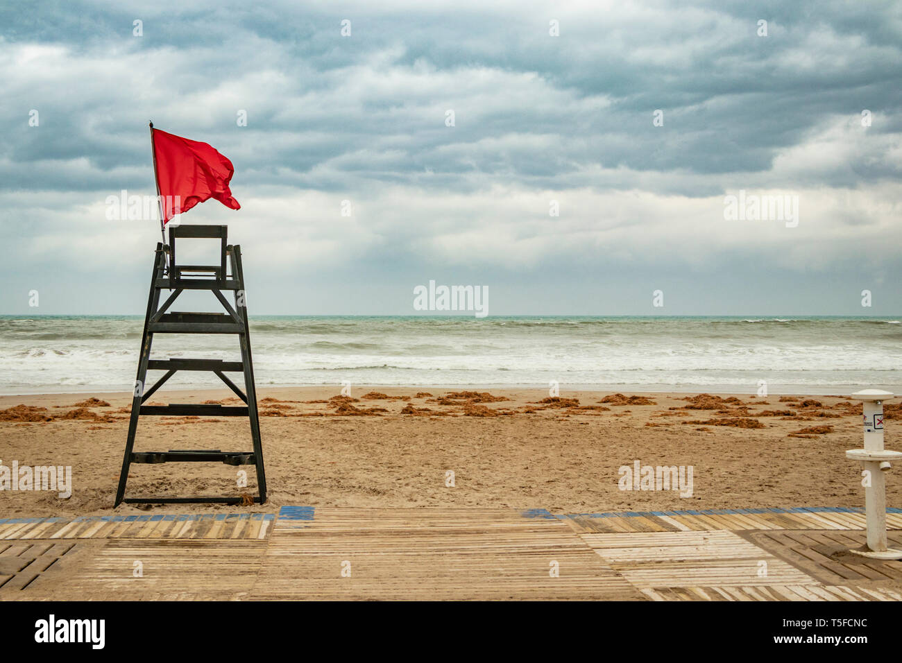 Bandiera rossa battenti da life guard sedia durante la tempesta di spiaggia a Alicante Spagna Foto Stock