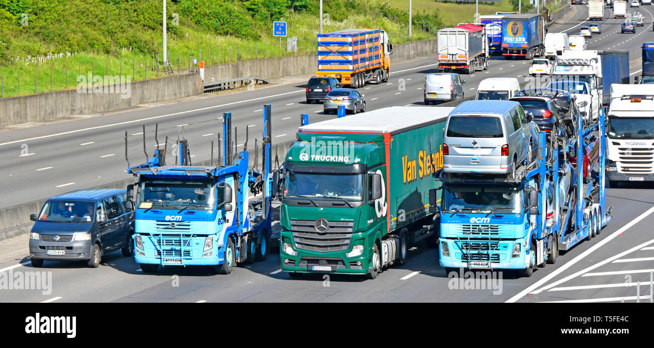 Guardando verso il basso sulla hgv camion Truck & rimorchio articolato veicoli in sorpasso trefolato fino il traffico su gradiente occupato quattro lane M25 Autostrada England Regno Unito Foto Stock