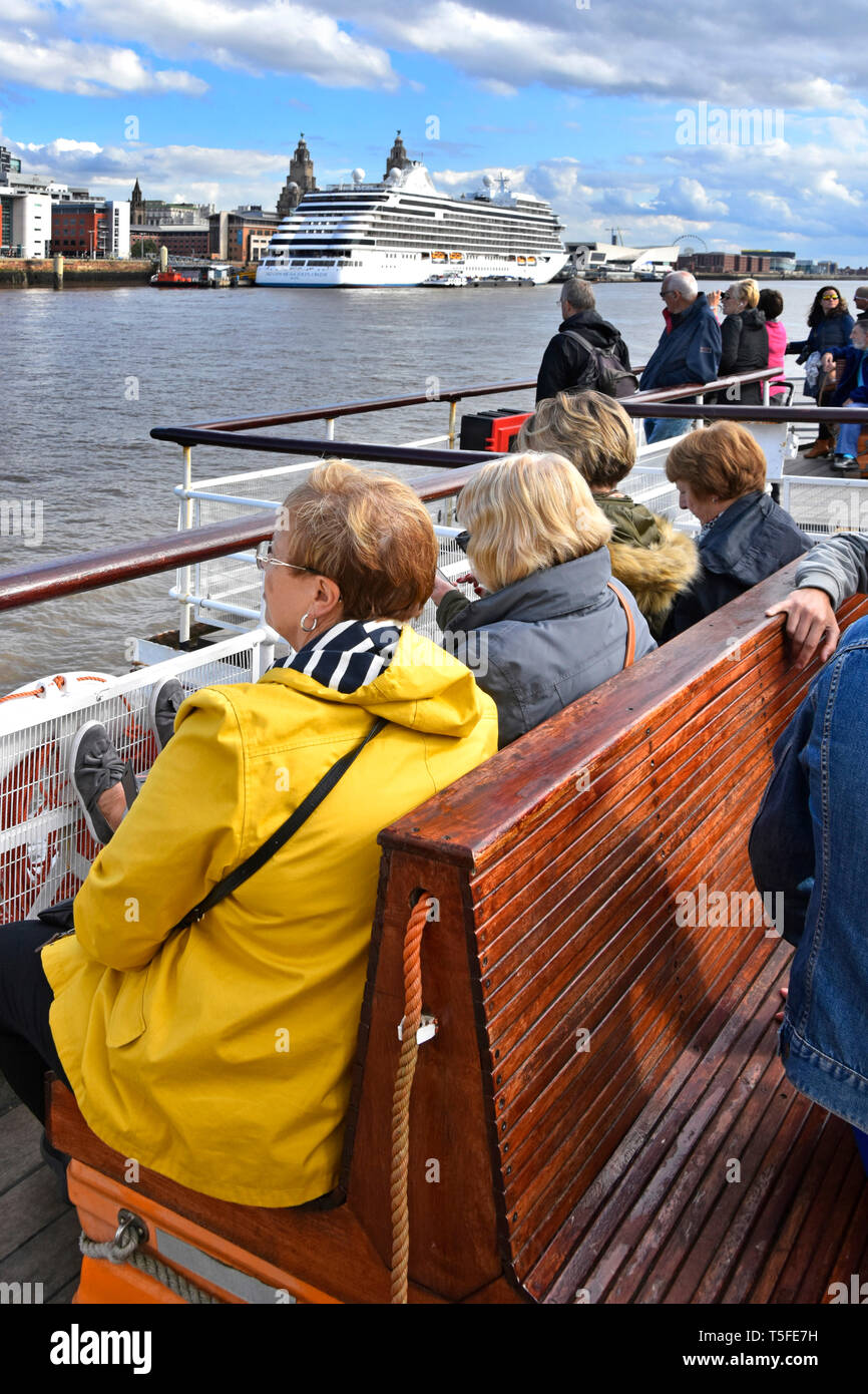 Gruppo di persone sul Mersey Ferries ferry boat si avvicina a Liverpool Pier Head sul fiume che attraversa da Wirral Cruise Ship Terminal al di là di Merseyside England Regno Unito Foto Stock