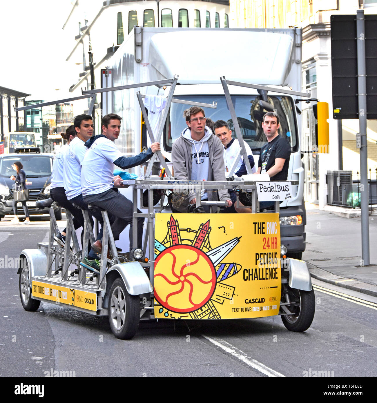 Chuggers o carità rapinatori gruppo di giovani asset management persone su Pedibus al pedale lungo la City of London street per raccogliere fondi per beneficenza Cascaid Foto Stock