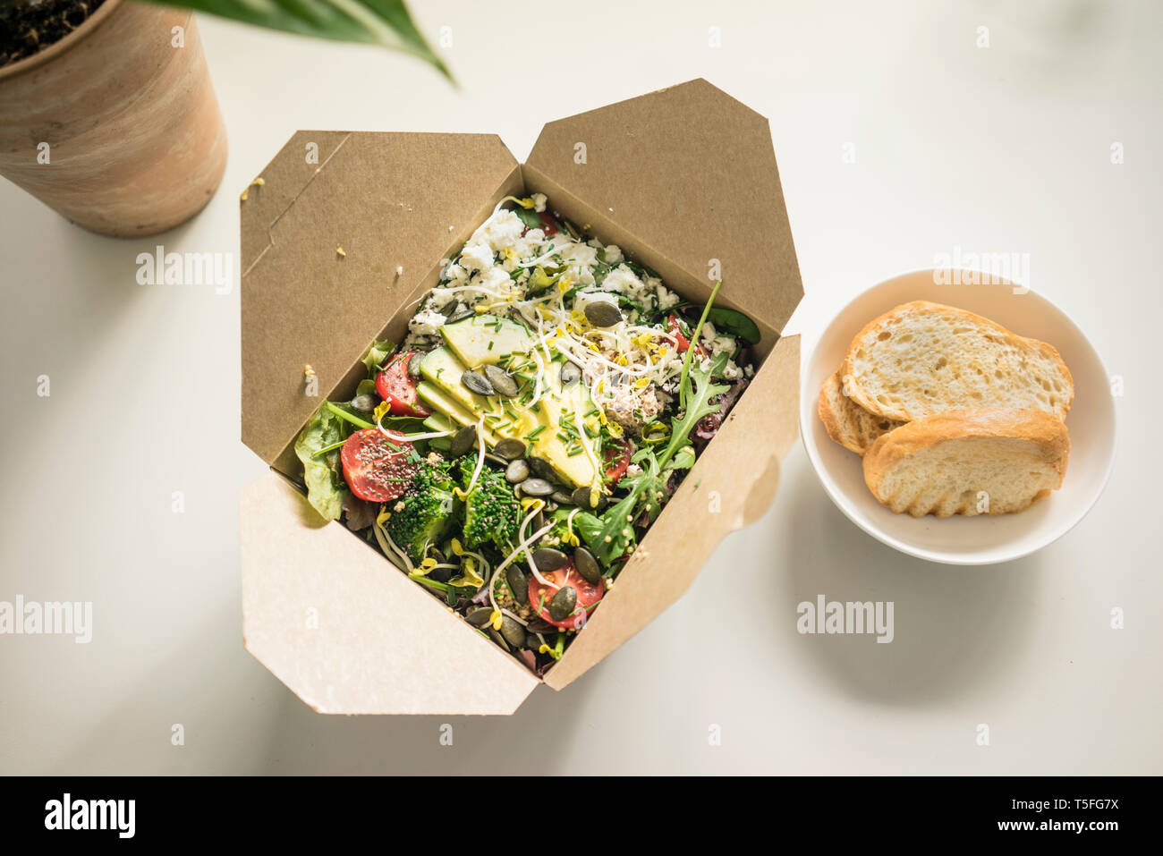 Scatola di pranzo con insalata fresca sulla scrivania Foto Stock