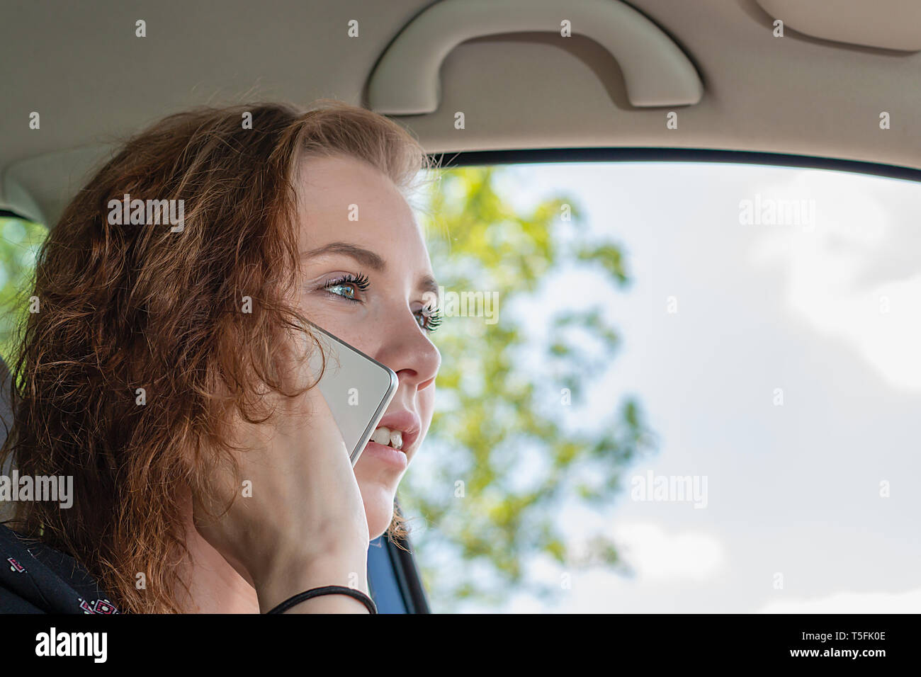 Giovane donna al telefono mentre si guida è distratto Foto Stock