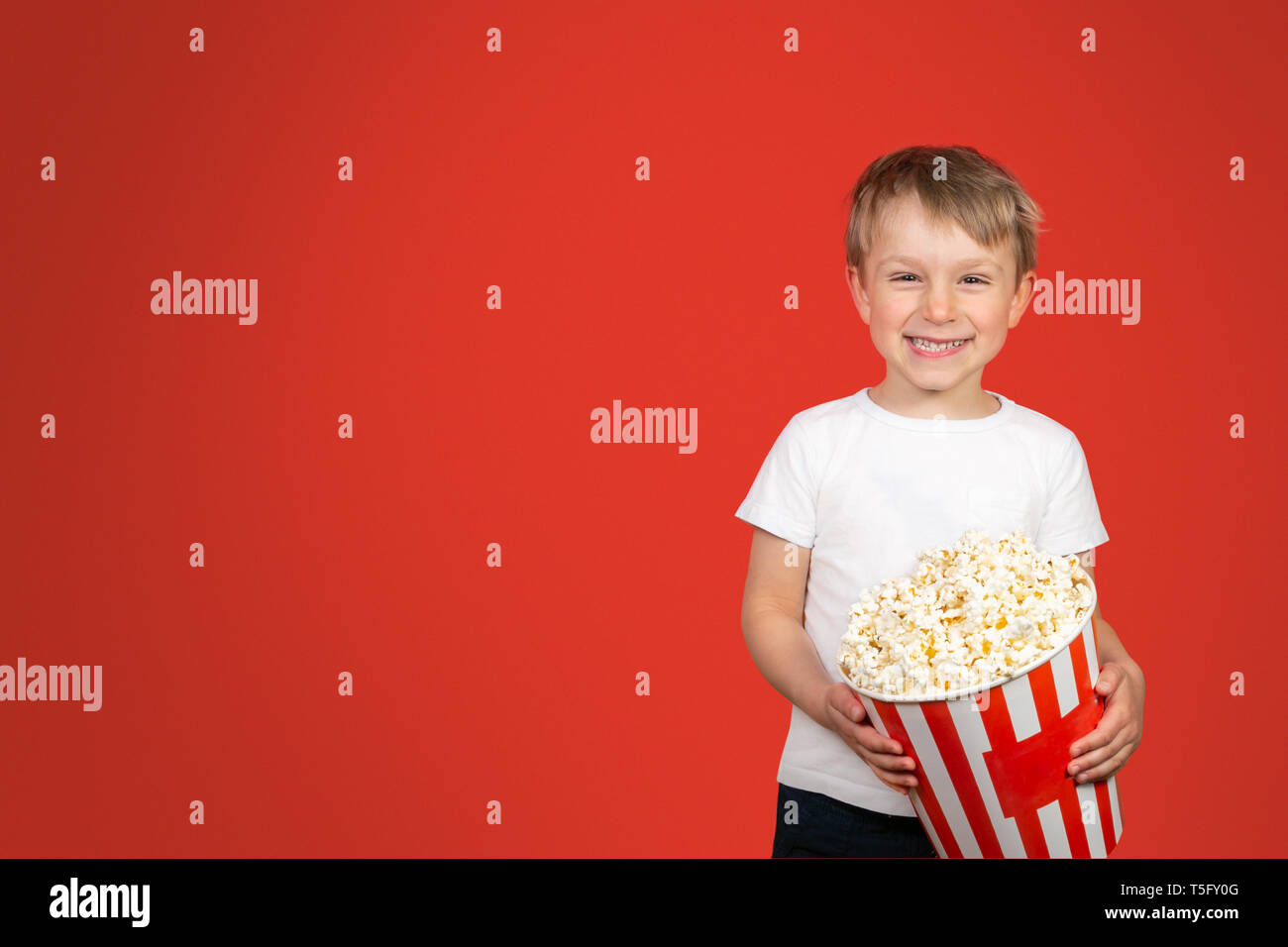 Concetto di film - boy holding enorme di popcorn Foto Stock