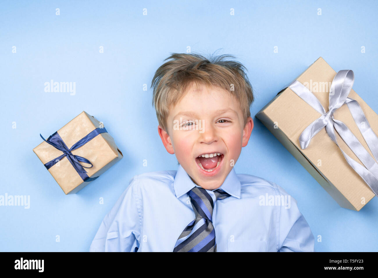 Padri giorno concetto - ragazzo indossa maglietta formale e tirante appena sfondo blu Foto Stock