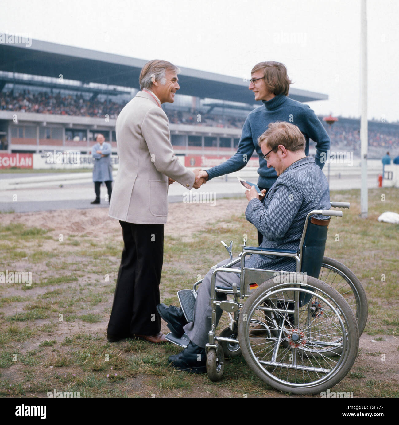 Fuchsberger begrüßt einen ventola Rollstuhl im abseits der Rennbahn, ca 1970. Fuchsberger accoglie un ventilatore in una sedia a rotelle fuori pista, ca 1970 Foto Stock