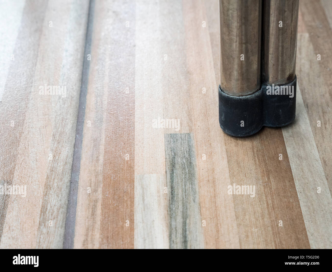 Gamba metallica della sedia moderna con il paraurti di colore nero per proteggere sul pavimento di piastrelle. Foto Stock