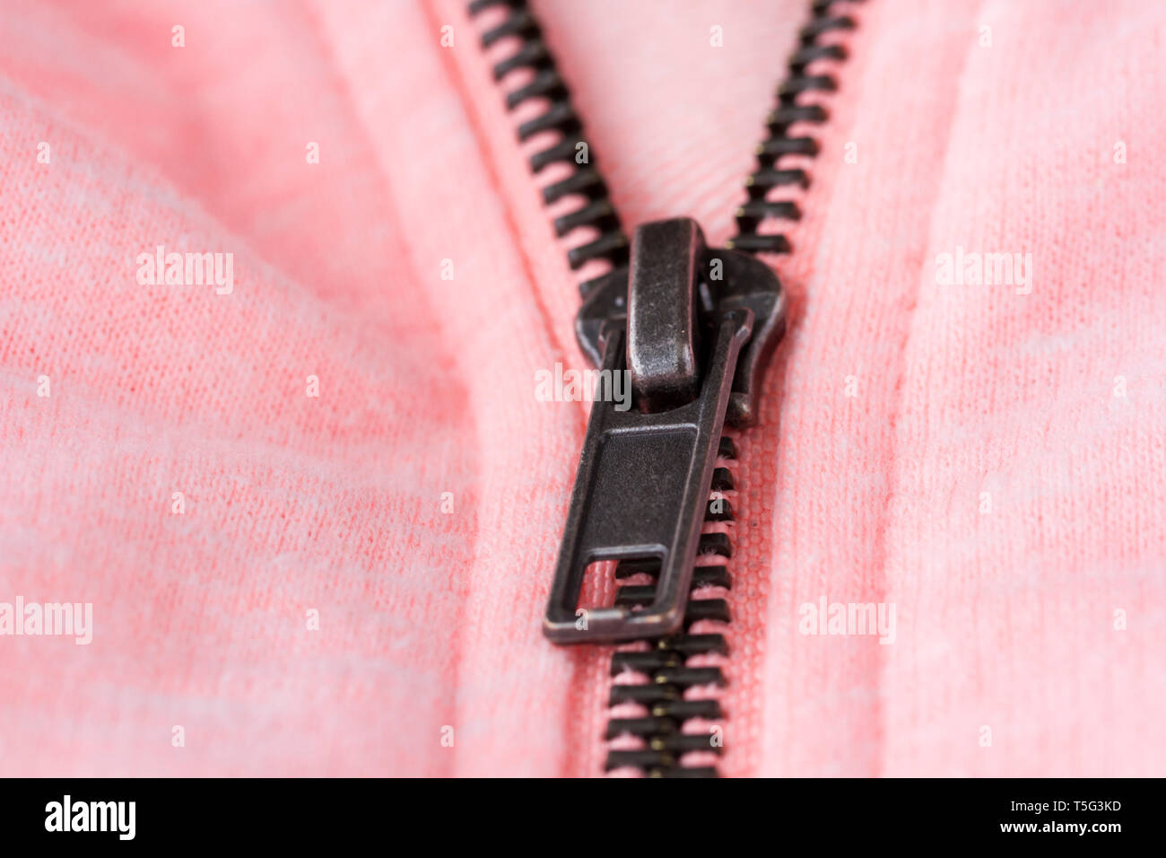 Vista ravvicinata di una zip su una camicia rosa Foto Stock