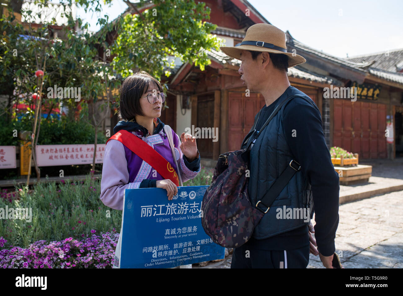 Lijiang, cinese della provincia dello Yunnan. 22 apr, 2019. Un volontario che aiuta un turista a Lijiang, a sud-ovest della Cina di Provincia di Yunnan, 22 aprile 2019. Secondo le autorità locali, il turismo ha iniziato a riscaldarsi quando un treno veloce servizio è stato lanciato tra Lijiang e capitale provinciale Kunming nei primi mesi del 2019. Durante la prima stagione, Lijiang accolto 12.325 milioni di arrivi e vide un totale delle entrate di 25.637 miliardi di yuan, fino 21,5 per cento e 15.13% rispettivamente rispetto all anno precedente. Credito: Hu Chao/Xinhua/Alamy Live News Foto Stock