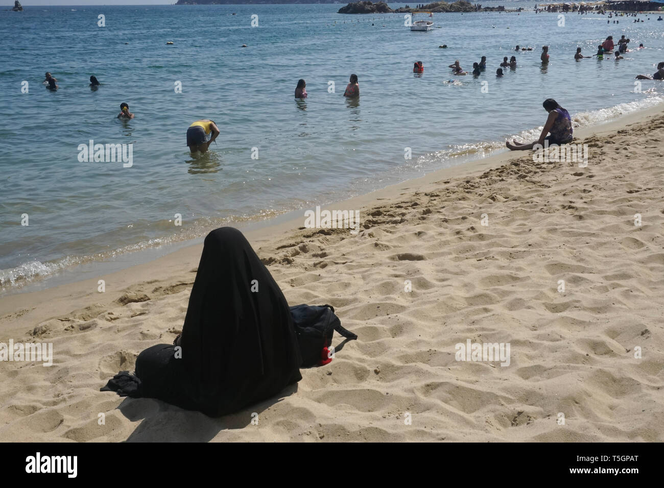 La donna a caldo abbigliamento religioso sulla spiaggia in Messico Foto Stock