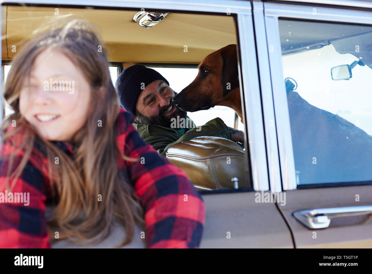 Felice la figlia con il padre e il cane in auto Foto Stock