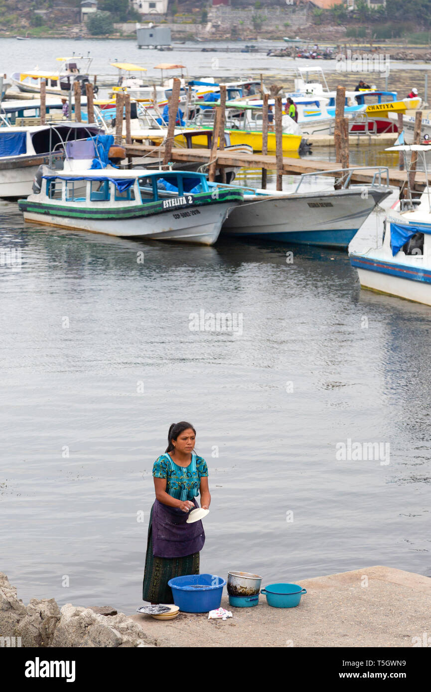 America centrale di stile - una donna del Guatemala il lavaggio delle stoviglie nel lago Atitlan, Santiago Atitlan, Guatemala America Centrale Foto Stock