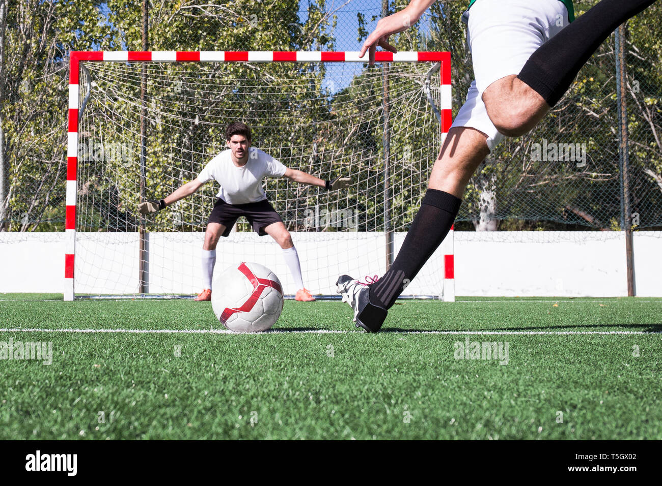 Giocatore di football riprese la palla sul campo di calcio Foto Stock