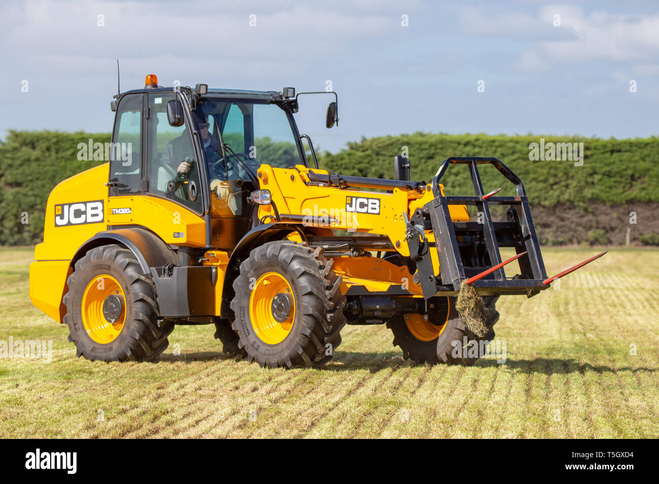 Kirwee, Canterbury, Nuova Zelanda, 27 marzo 2019: un agricoltore dimostra un movimentatore telescopico JCB al lavoro haybales impilamento, Isola del Sud Campo agricolo giorno Foto Stock