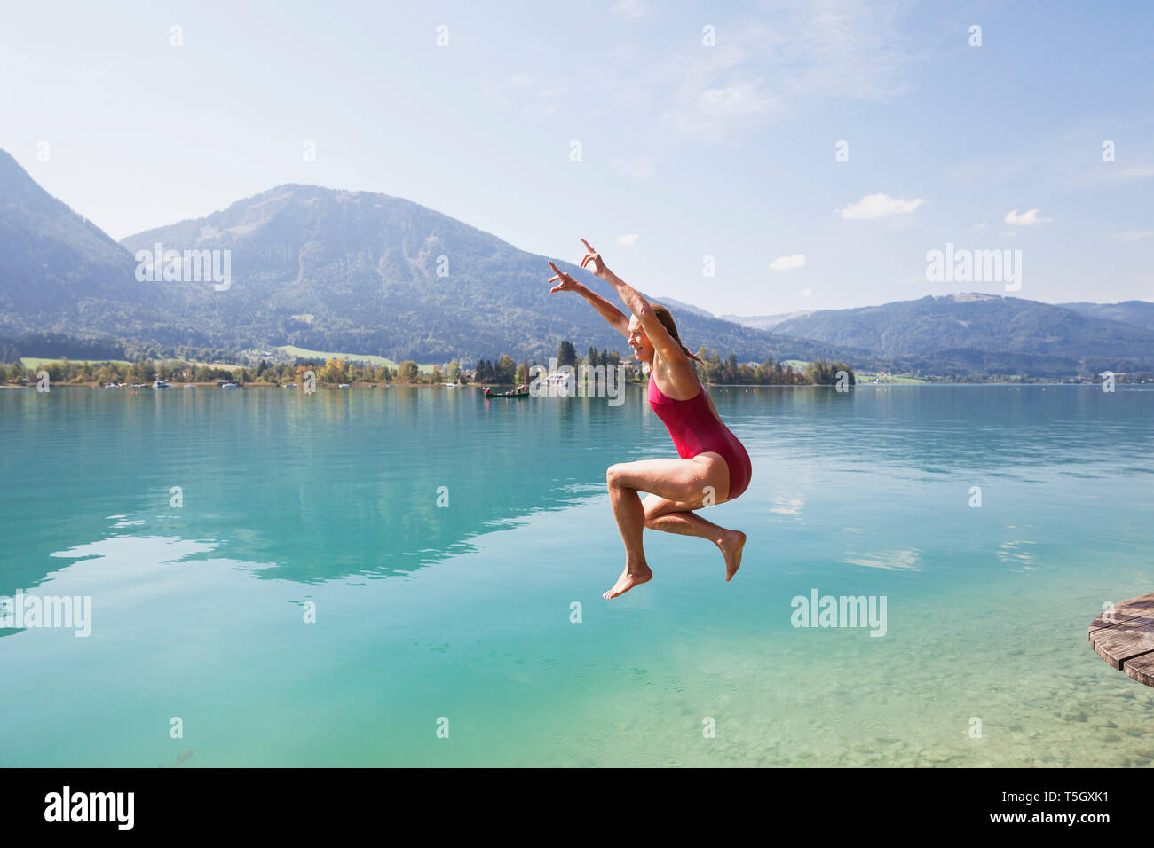Austria, Alpi, Salisburgo, Salzkammergut, Salzburger Land, Wolfgangsee, donna che si tuffa nel lago Foto Stock