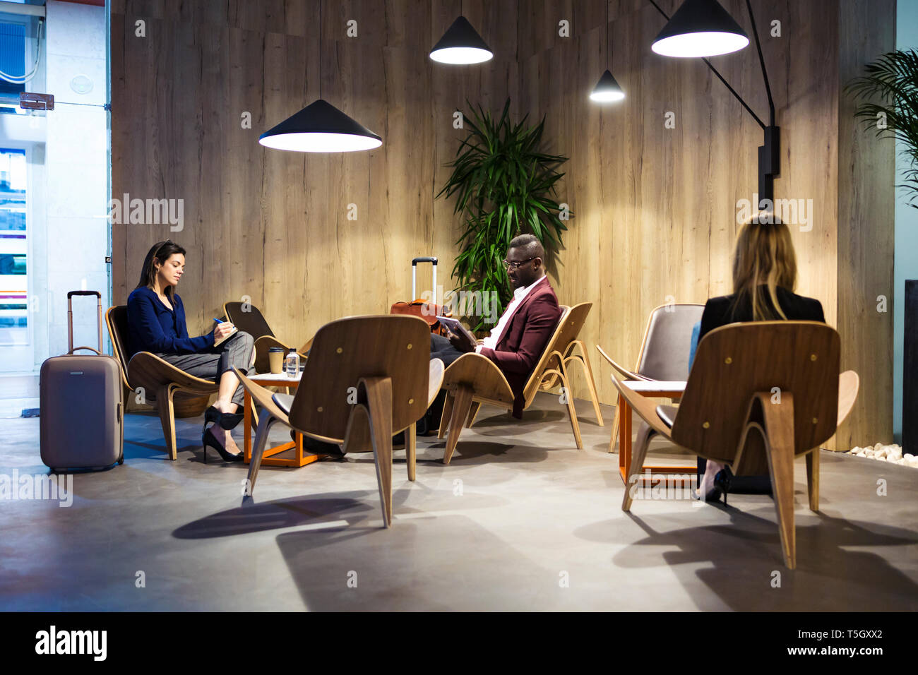 La gente di affari seduti nella hall dell'albergo, lavorando Foto Stock