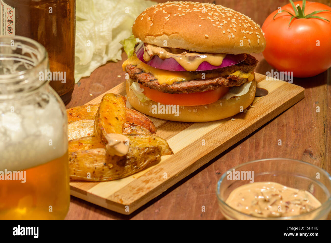 Tijuana, Baja California, Messico - 04/17/2019: Burger e birra con patate fritte e chipotle mayo, spazio di copia Foto Stock