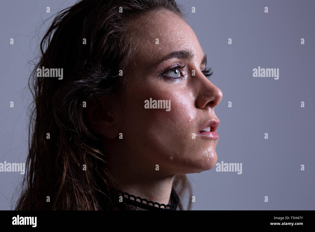 Ritratto di giovane donna con il viso bagnato dopo la doccia a pioggia Foto Stock