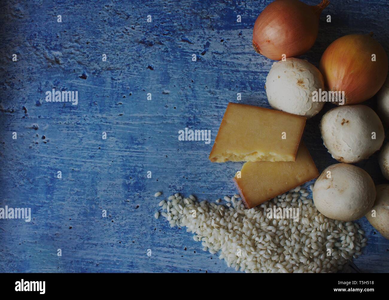 Risotto ai funghi Ingredienti su rustiche dipinte di blu sullo sfondo Foto Stock