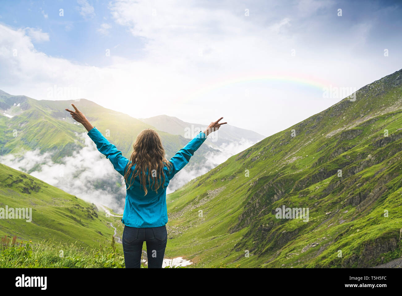 Donna felice alzando le braccia e guardando oltre le montagne dei Carpazi, Romania Foto Stock