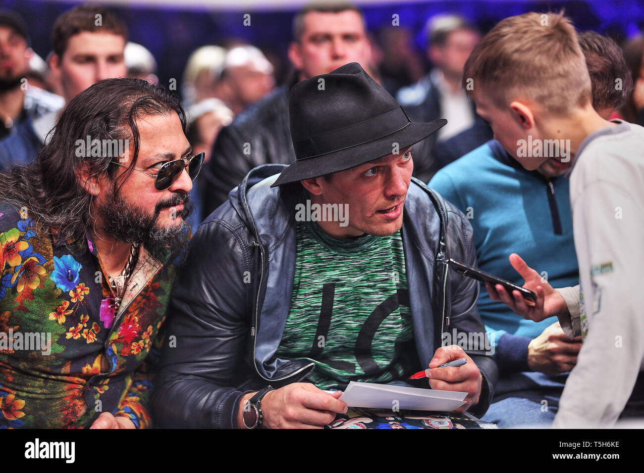 Ucraina la boxe meraviglia assoluta Cruiserwght World Champ, Londra2012 Olympic champ, Alex Usyk segni autografo per un ragazzo al ringside, Kiev Palazzo dello Sport Foto Stock