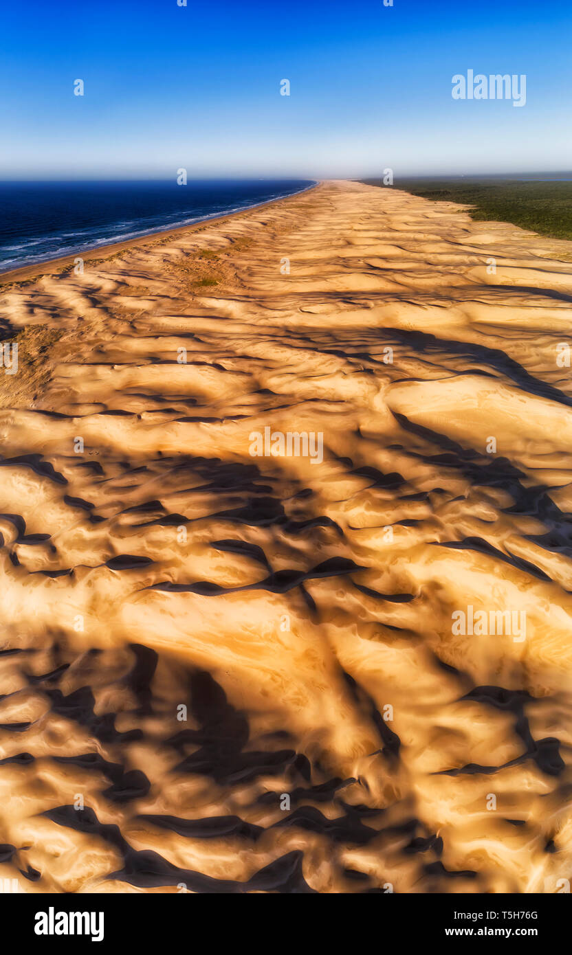 Il vento di superficie erosa di dune di sabbia in Stockton Beach Pacific Coast in Australia. Antenna di elevata panorama verticale dalla parte superiore verso il basso per lontano orizzonte e Foto Stock