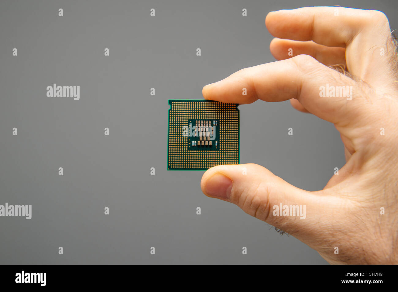 Maschio di mano azienda nuova CPU potente unità di elaborazione centrale con elevato numero di core e frequenza elevata - isolato su grigio Sfondo office Foto Stock
