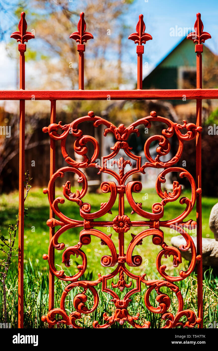 Di colore rossastro intricato cancellata in ferro battuto e recinzione Foto Stock