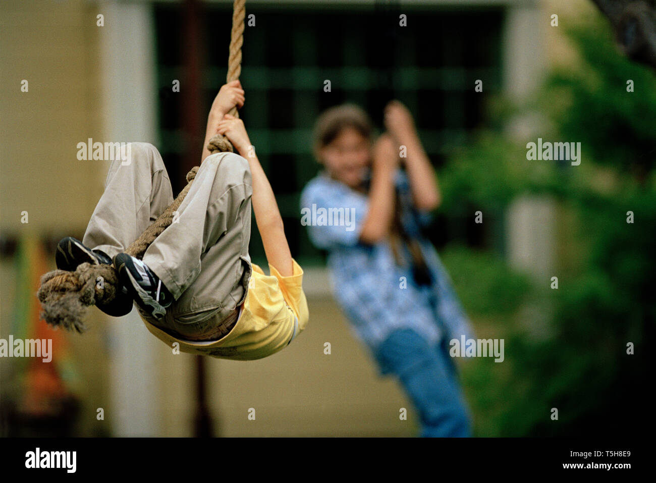 Un ragazzo e una ragazza giocando su swing corda Foto Stock