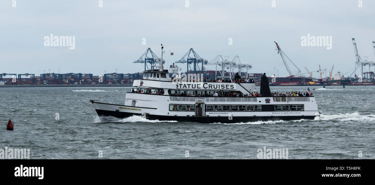 New York, Stati Uniti d'America - 15 Ottobre 2017: la statua della libertà di barche di crociera sono pieni di capacità su una calda giornata di ottobre. Foto Stock