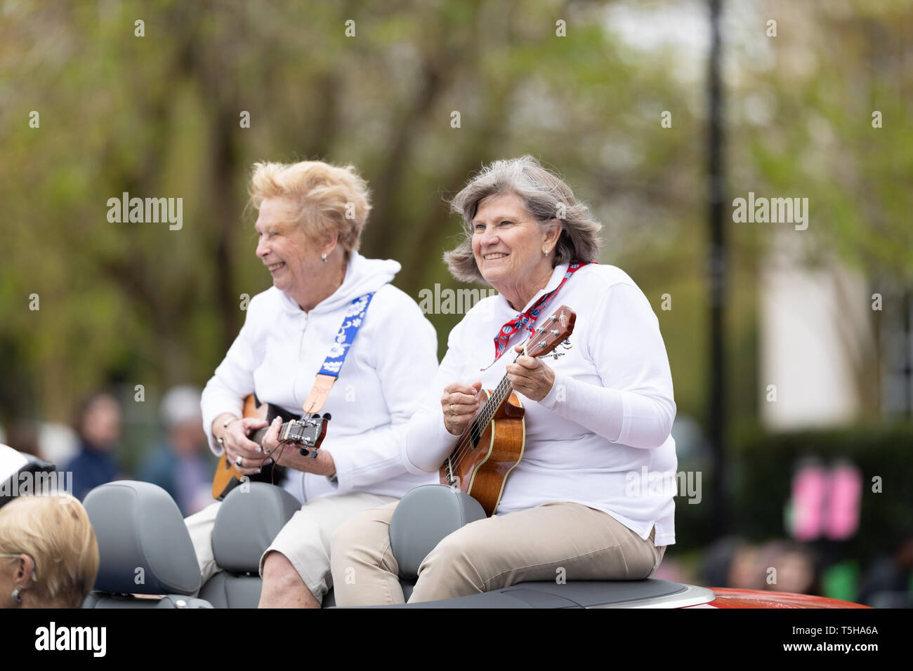 Wilmington, Carolina del Nord, Stati Uniti d'America - Aprile 6, 2019: Il North Carolina Azalea Festival, membri della leggermente il tasto off stringalongs salire su una vettura di riproduzione Foto Stock