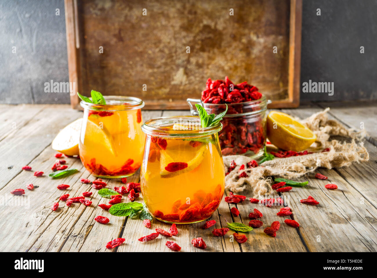 In casa goji tè caldo con la menta e le fette di limone, rustico in legno sfondo spazio di copia Foto Stock