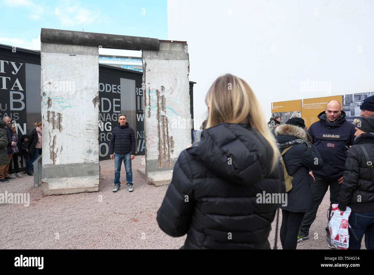 Berlino, Germania - i turisti posano per le foto accanto a una sezione del muro di Berlino vicino al Checkpoint Charlie Foto Stock