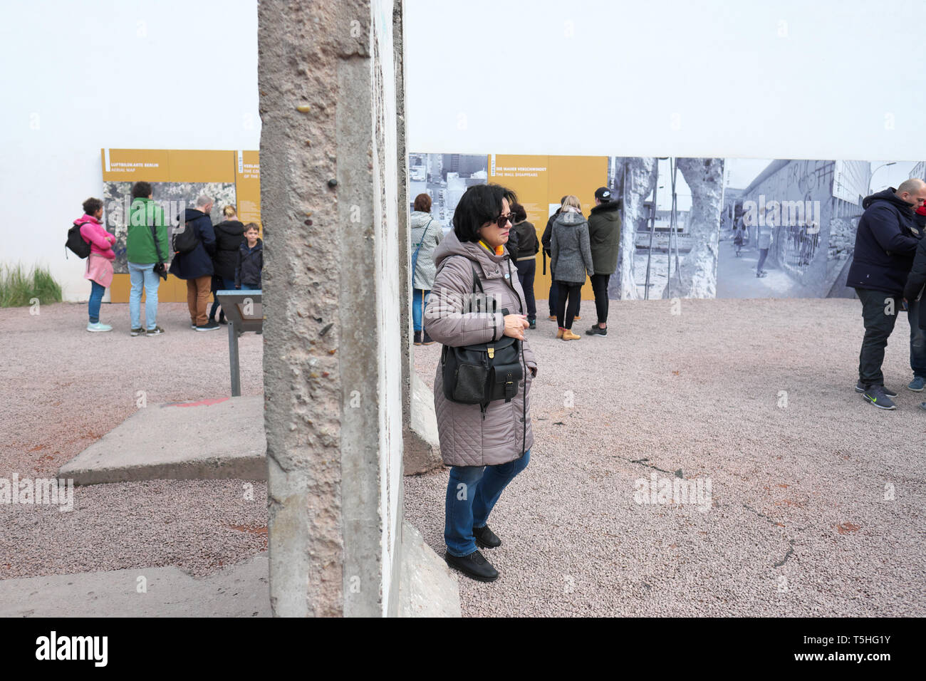 Berlino, Germania - i turisti posano per le foto accanto a una sezione del muro di Berlino vicino al Checkpoint Charlie Foto Stock