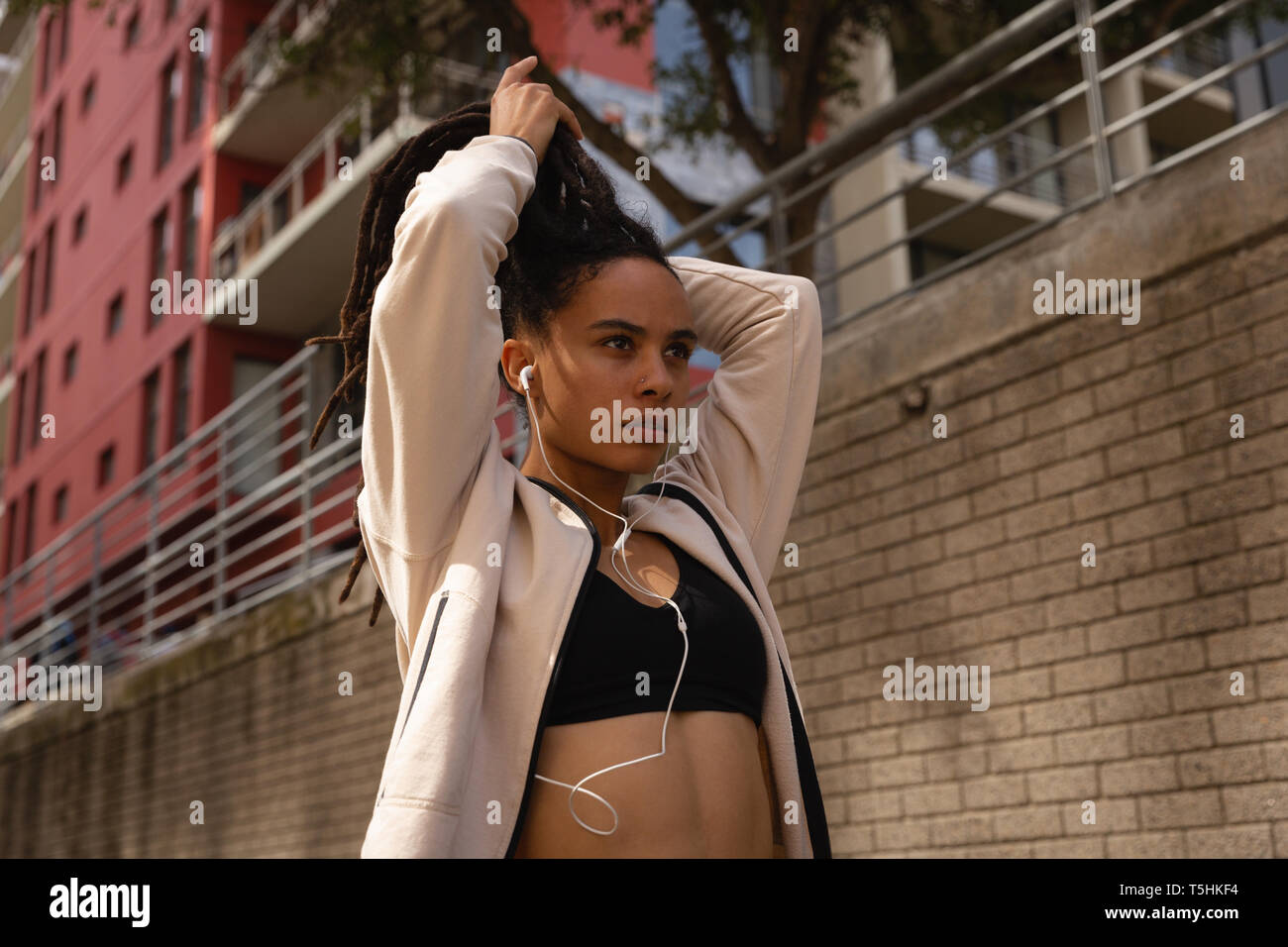Giovane donna la sua legatura updo nella città Foto Stock