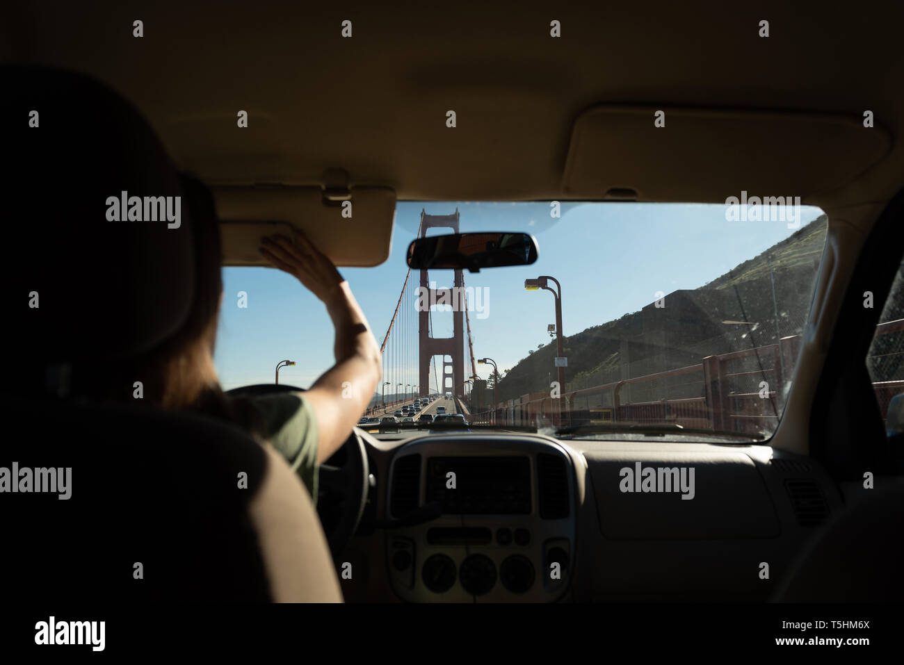 Donna alla guida di auto oltre il Golden Gate bridge Foto Stock