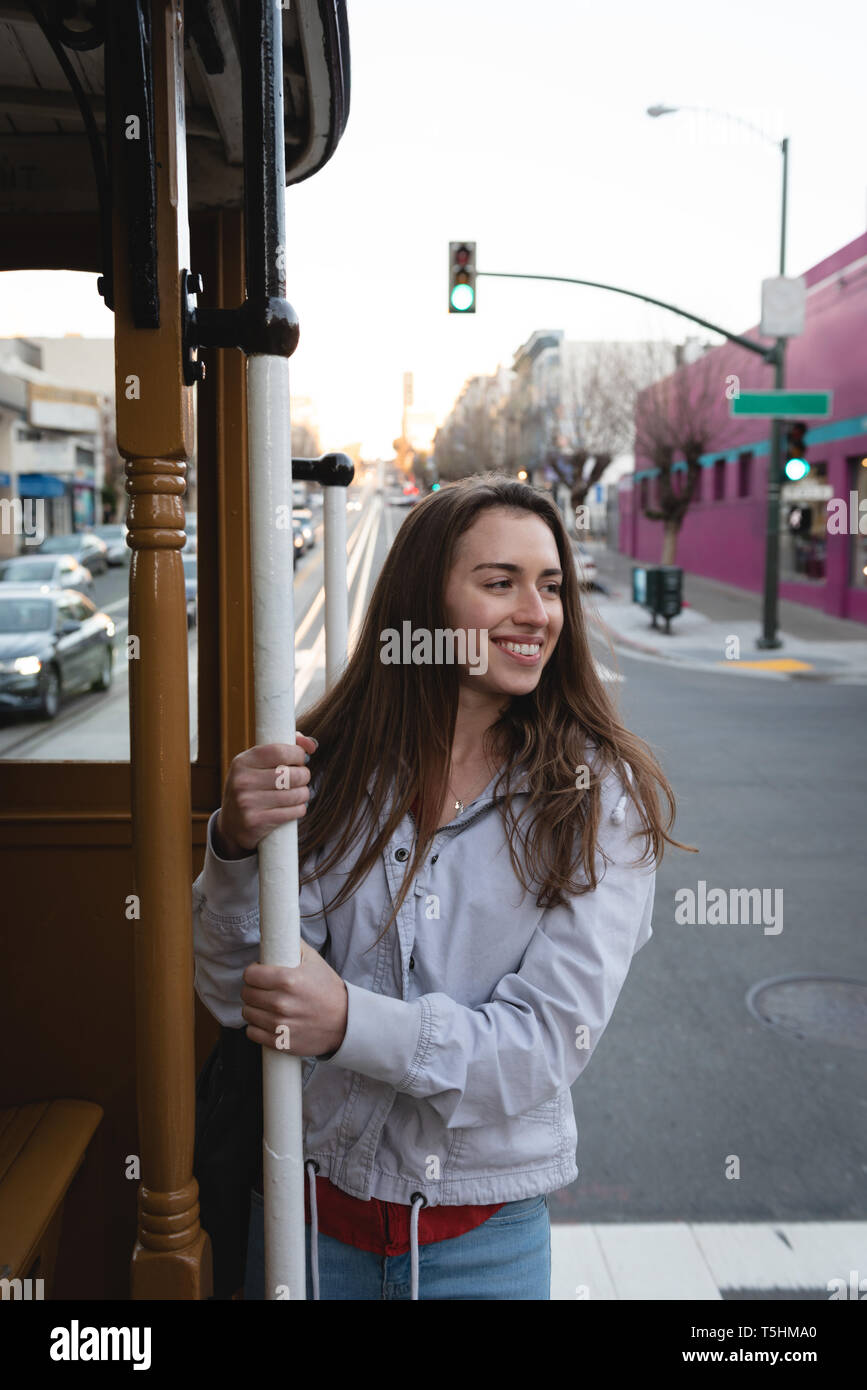 Donna felice appeso al di fuori del veicolo in movimento Foto Stock